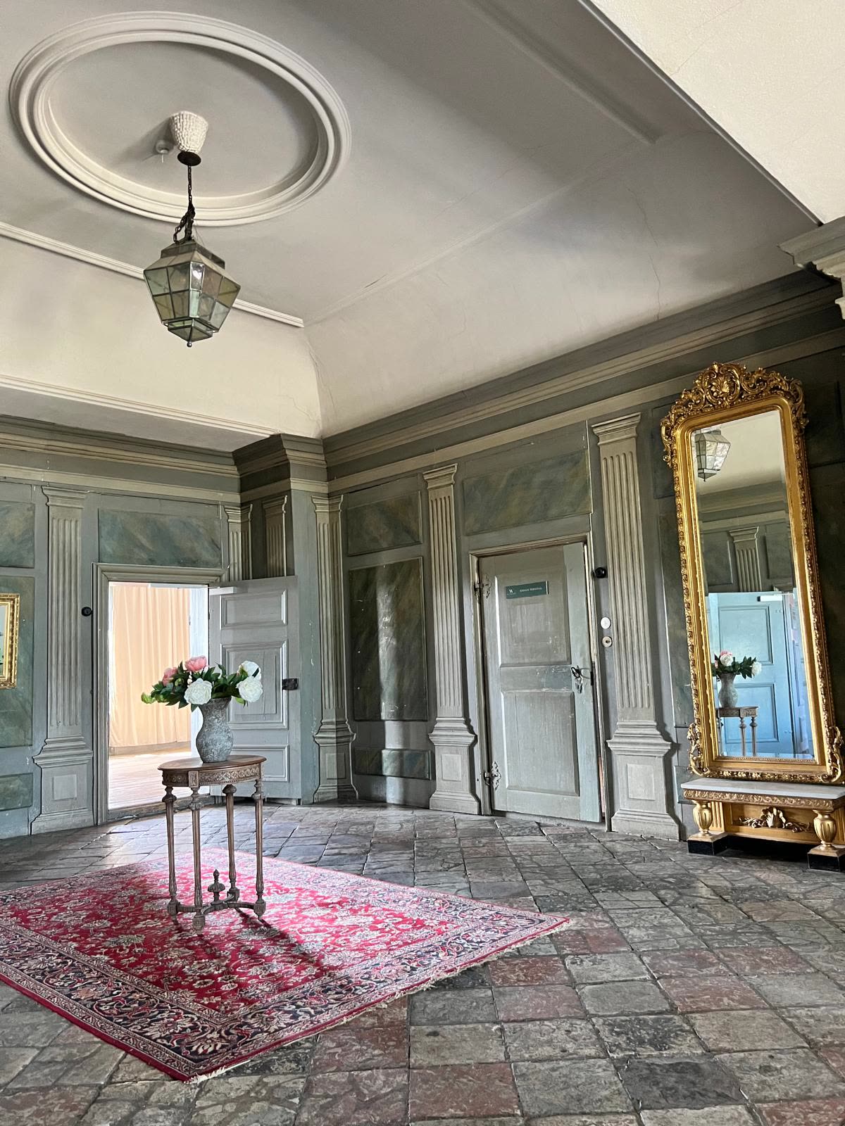 Entréhallens stengolv, pilastrar och gustavianska panelväggar
