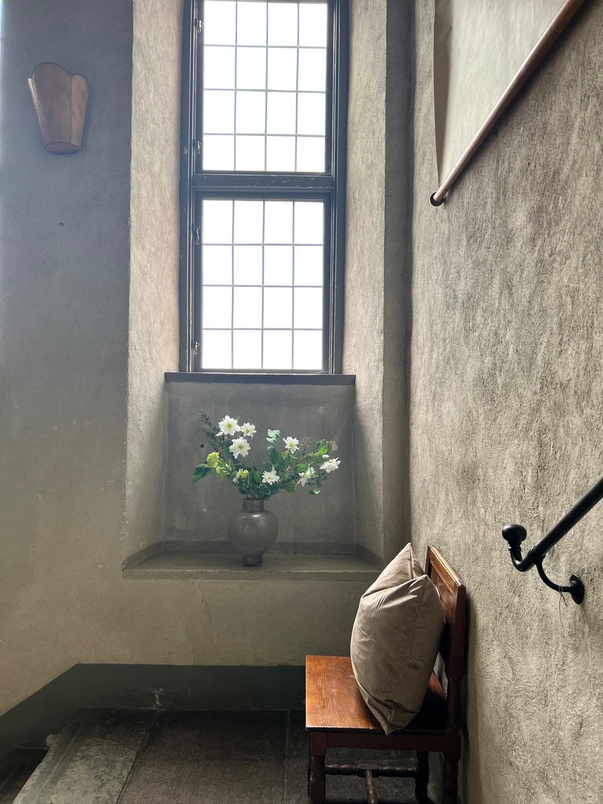 Slottets trapphus med blommor i fönsternischen