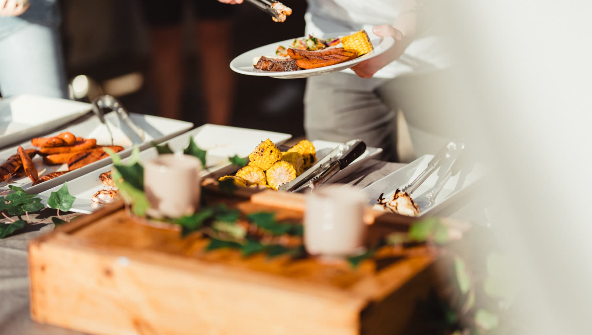 Serveringspersonal lägger upp grillat från buffén
