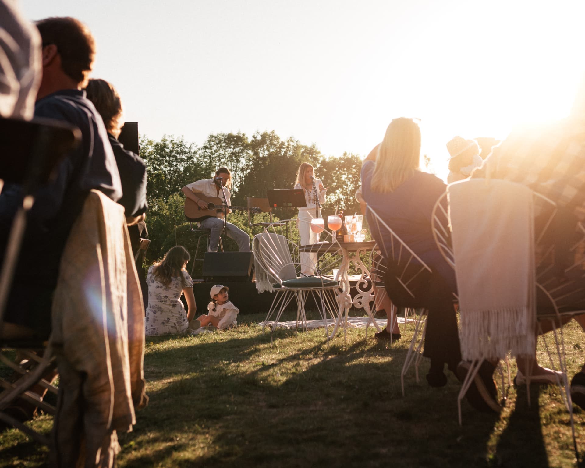 Publik framför scenen i slottsparken i solnedgång