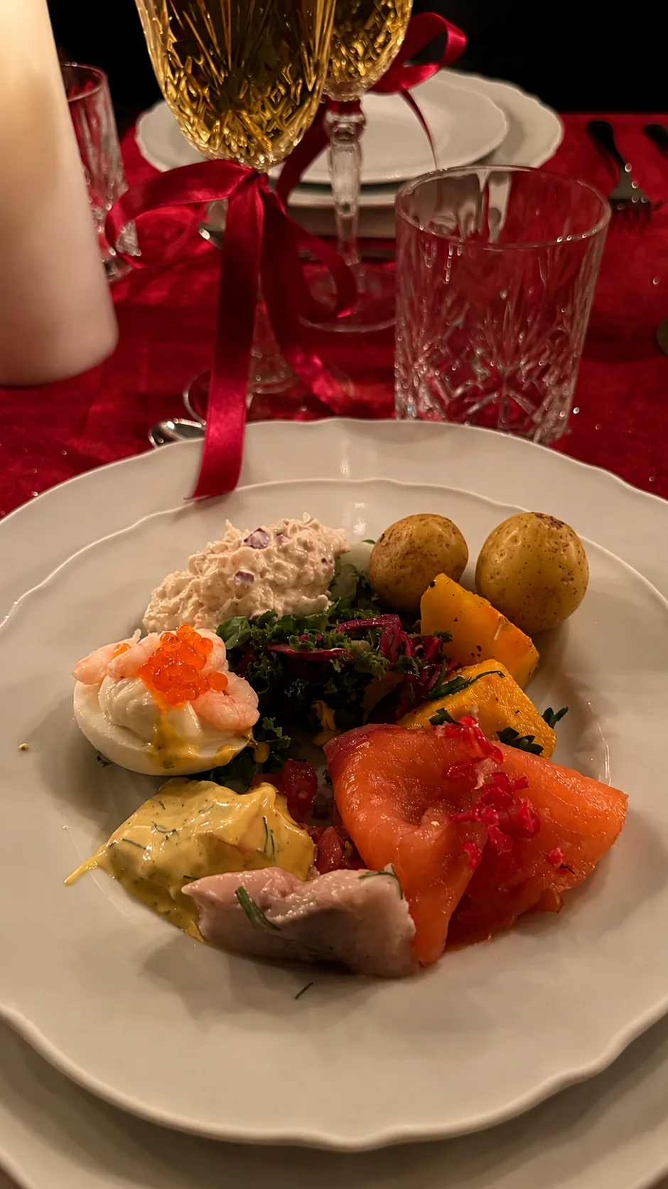 Tallrik med gravad lax, skagenröra och färskpotatis vid levande ljus