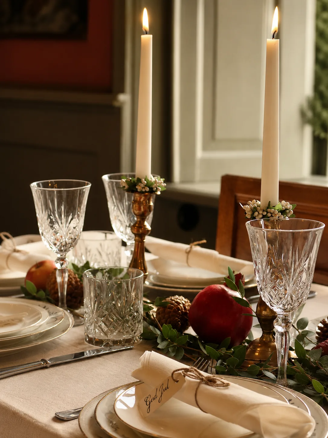 Festdukning i dagsljus med kristallglas, mässingsljusstakar och granatäpplen