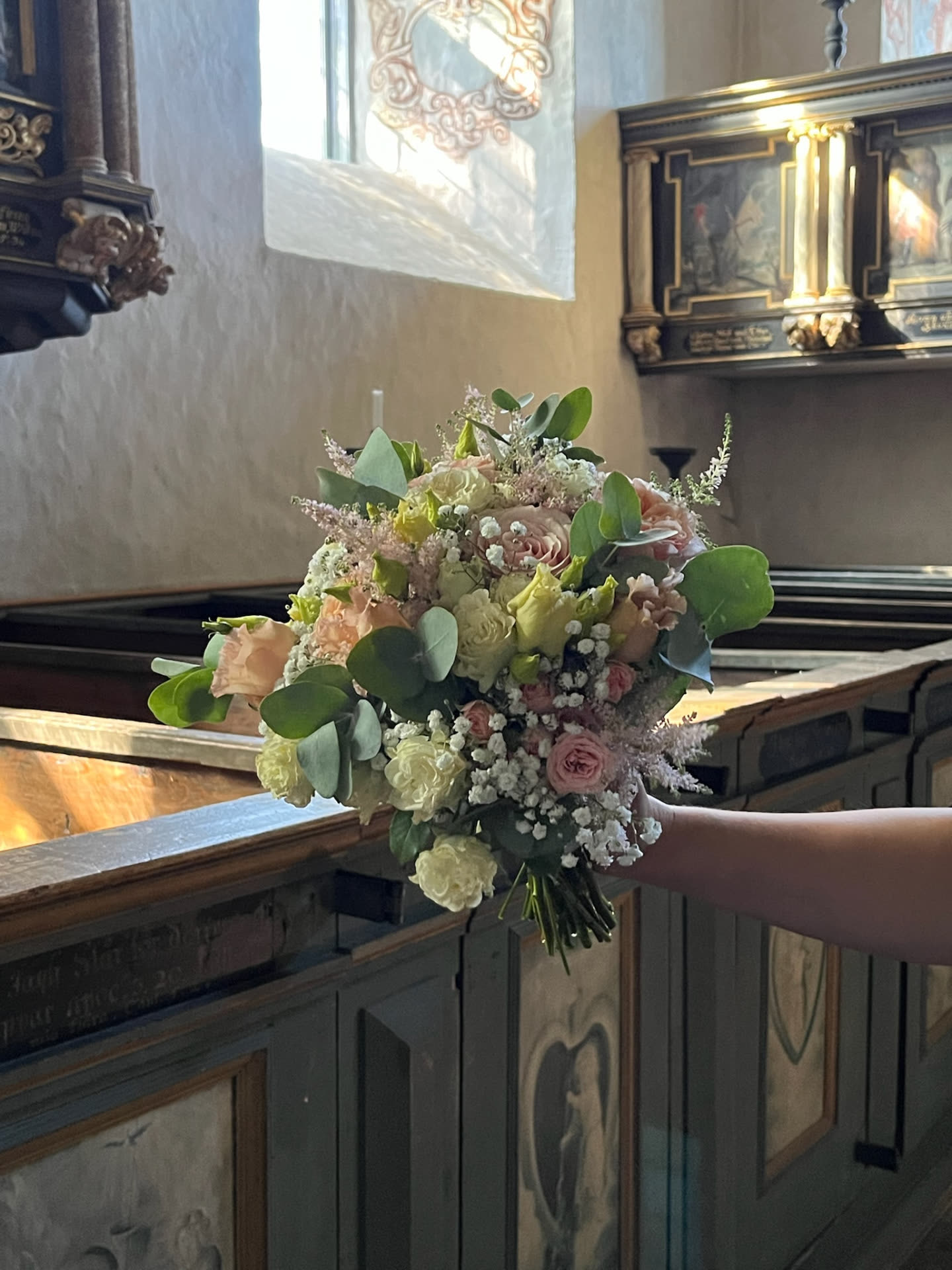 Brudbukett i pastell i kyrkans ljus